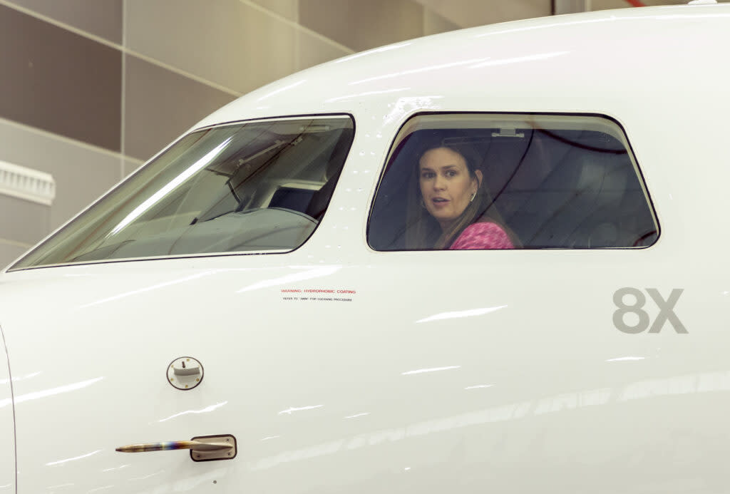 Gov. Sarah Huckabee Sanders looks out the cockpit window of a Falcon business jet on Dec. 12, 2023, after Dassault Falcon Jet CEO Thierry Betbeze announced the French company would invest “tens of millions” in its Little Rock facility and 800 jobs. (John Sykes/Arkansas Advocate)