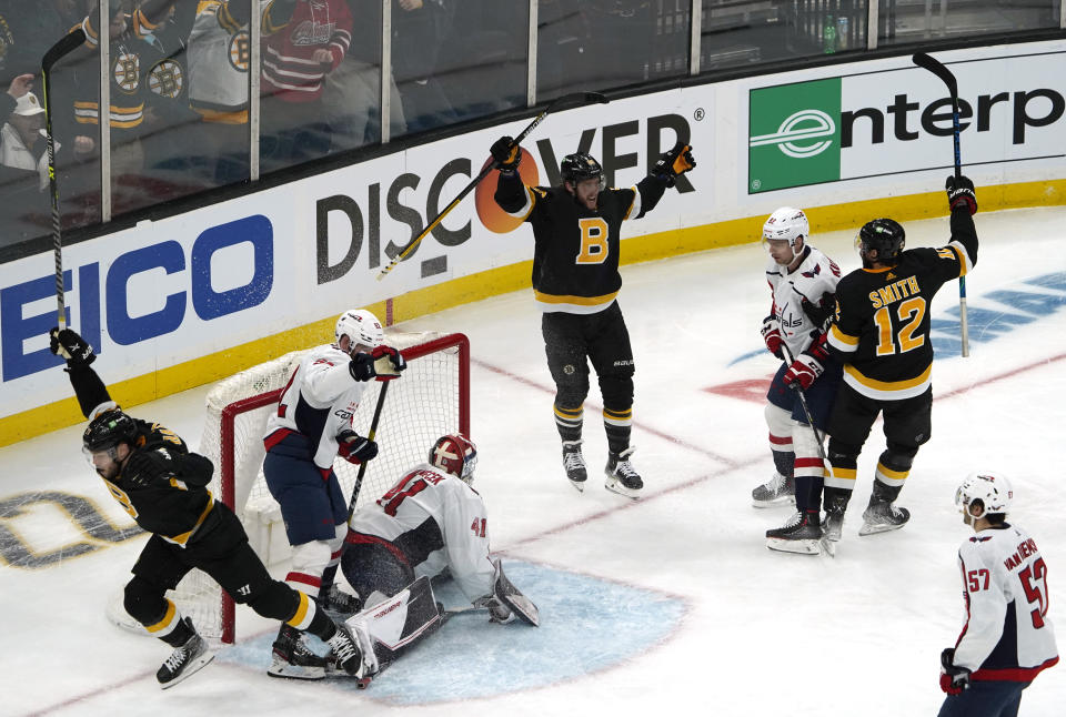 Boston Bruins right wing David Pastrnak, center, celebrates with teammates after scoring a goal on a breakaway past Washington Capitals goaltender Vitek Vanecek (41) during the second period of an NHL hockey game, Thursday, Jan. 20, 2022, in Boston. (AP Photo/Mary Schwalm)