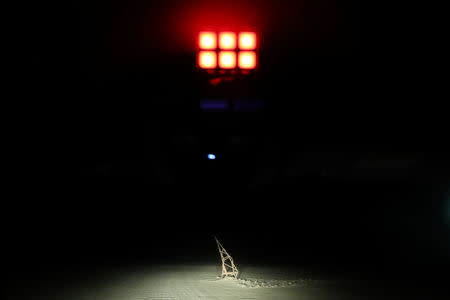 A damaged border post is illuminated during a police patrol at a restricted mined area at the Chilean and Peruvian border, in Arica, Chile, November 15, 2018. REUTERS/Ivan Alvarado