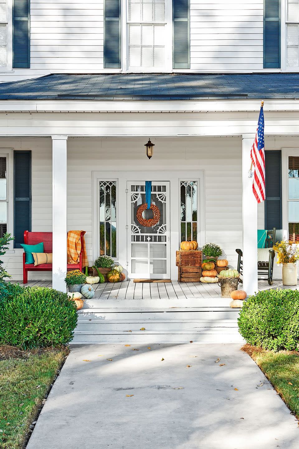 <p>Hang your fall wreath with a bright ribbon. Then add a ton of pumpkins (bonus points for using apple crates as a pedestal). </p>