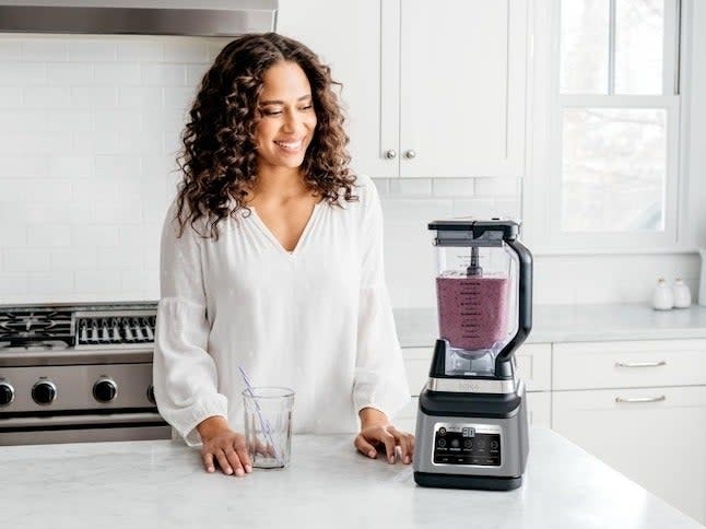 model standing next to the blender