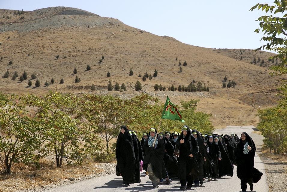 In this Thursday, Aug. 22, 2013 photo, female members of the Basij paramilitary militia march during training session in Tehran, Iran. With a presence in nearly every city and town across Iran, the paramilitary Basij volunteer corps has an ever-increasing influence on life in the Islamic Republic. (AP Photo/Ebrahim Noroozi)