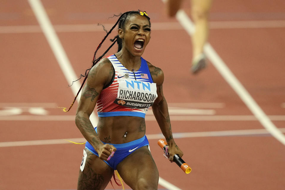 FILE - Sha'Carri Richardson, of the United States, celebrates after she crosses the finish line to anchor her team to gold in the Women's 4x100-meters relay final during the World Athletics Championships in Budapest, Hungary, Aug. 26, 2023. There is one more item to scratch off the list before everyone from Richardson to Noah Lyles to Sydney McLaughlin-Levrone embark on their trips to Paris for the Olympics: Making the Olympic team. US track trials start Friday, June21, 2024. (AP Photo/Martin Meissner, File)