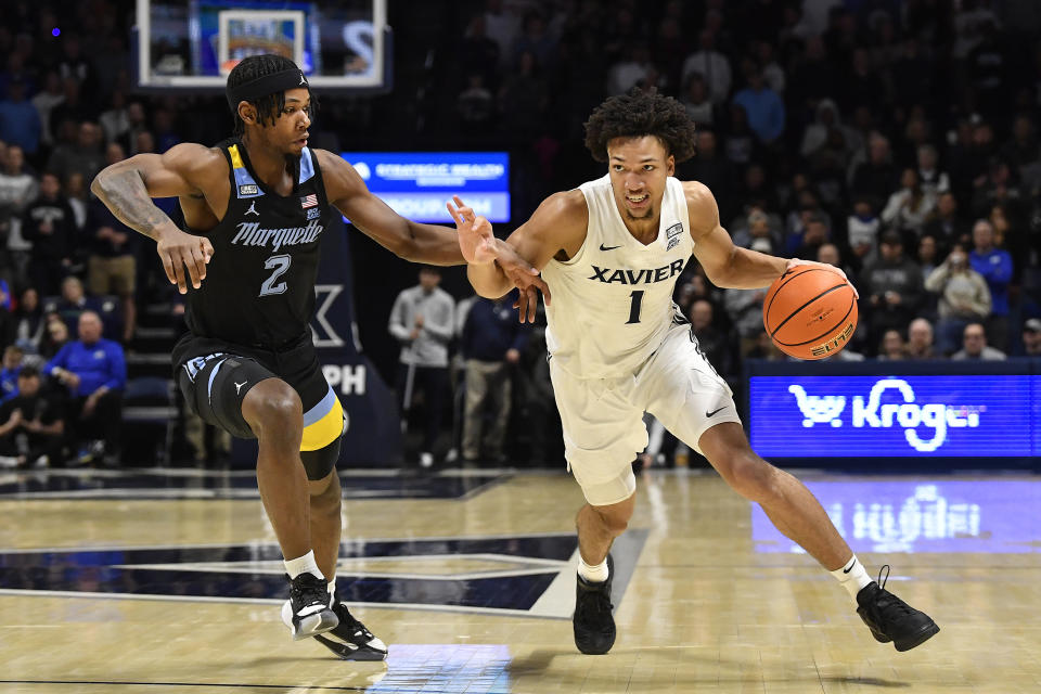 Xavier guard Desmond Claude (1)) drives past Marquette guard Chase Ross (2) during the first half of an NCAA college basketball game in Cincinnati, Saturday, March 9, 2024. (AP Photo/Timothy D. Easley)