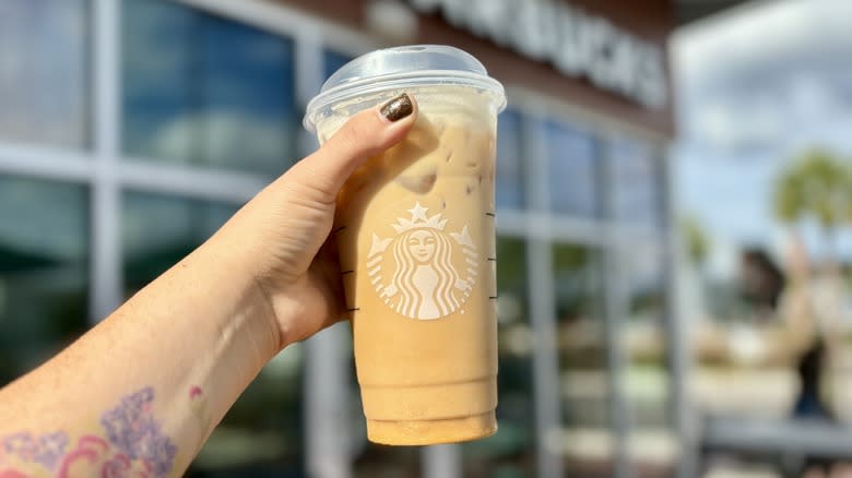 Holding Iced Hazelnut Oatmilk Shaken Espresso