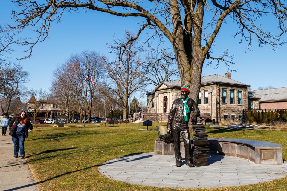 A bronze statue of World War II veteran and professional photographer Duane Zemper is dressed in a winter hat and scarf outside the Howell Carnegie District Library on Feb. 6, 2024.