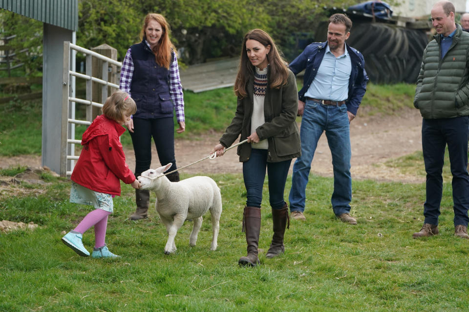 <p>The Duchess of Cambridge and farmer's daughter Clover Chapman, 9, walk a lamb together, watched by her parents and the Duke of Cambridge, during a royal visit to Manor Farm in Little Stainton, Durham. Picture date: Tuesday April 27, 2021.</p>
