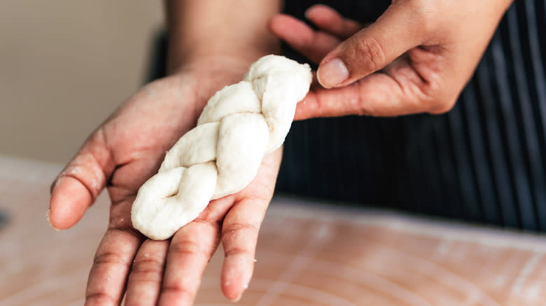 baker holding braided dough