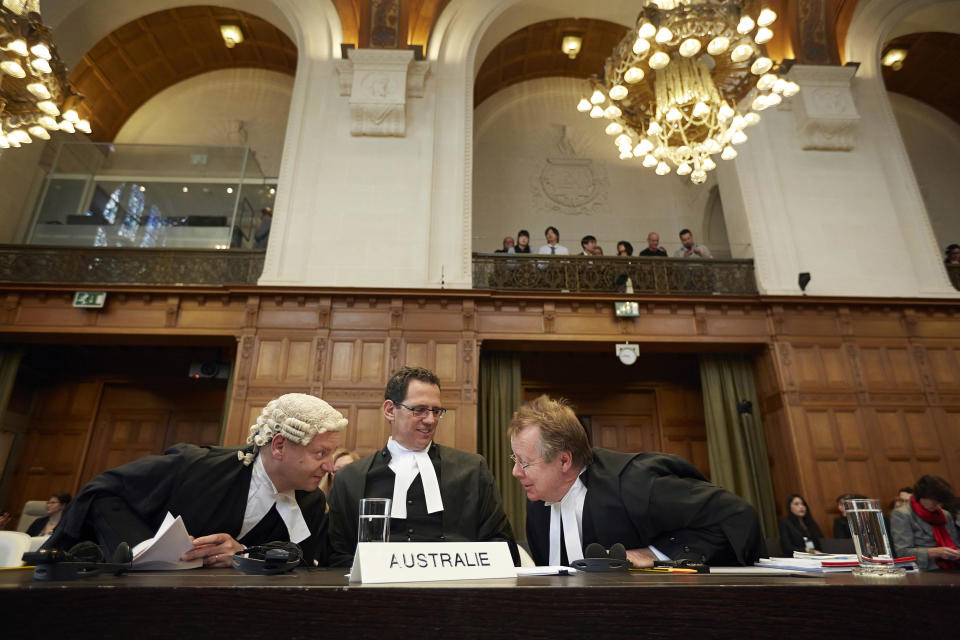 Australian Professor of Law, Philippe Sands, left, Justin Gleeson, center, and Bill Campbell, right, wait for the International Court of Justice to deliver its verdict in The Hague, Netherlands, Monday March 31, 2014. The International Court of Justice is ruling Monday on Australia's challenge against Japan for whaling in Antarctic waters. (AP Photo/Phil Nijhuis)