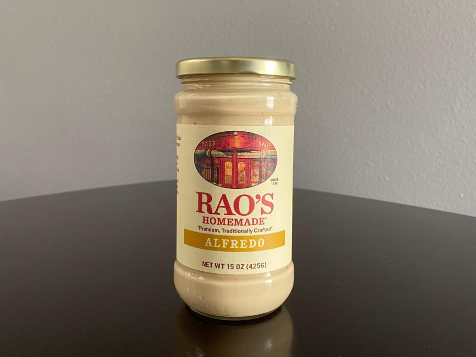 Jar of Rao's Alfredo sauce on a black table