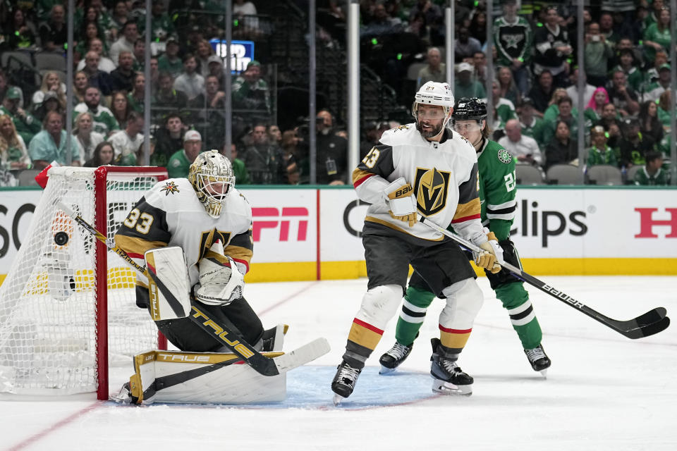 Vegas Golden Knights goaltender Adin Hill (33) deflects a shot as Alec Martinez (23) and Dallas Stars left wing Joel Kiviranta (25) watch during the third period of Game 4 of the NHL hockey Stanley Cup Western Conference finals Thursday, May 25, 2023, in Dallas. (AP Photo/Tony Gutierrez)