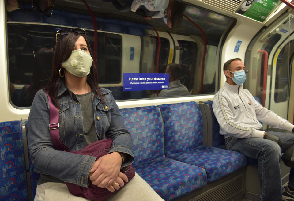 Passengers wear face masks on a Central Line underground train, following the announcement that wearing a face covering will be mandatory for passengers on public transport in England from June 15. (Photo by Nick Ansell/PA Images via Getty Images)