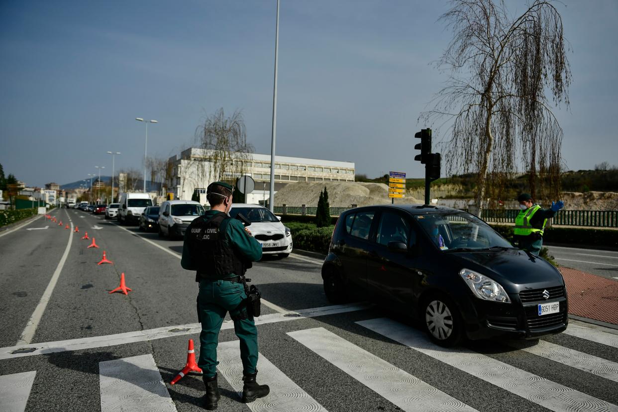 Spanish Civil Guard officers at a checkpoint to stop drivers from trying to leave the city, in Pamplona, northern Spain, Saturday, March 21, 2020.