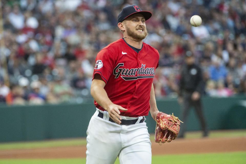 Cleveland Guardians starting pitcher Tanner Bibee tosses out Texas Rangers' Jonah Heim at first base during the third inning of a baseball game in Cleveland, Saturday, Sept. 16, 2023. (AP Photo/Phil Long)