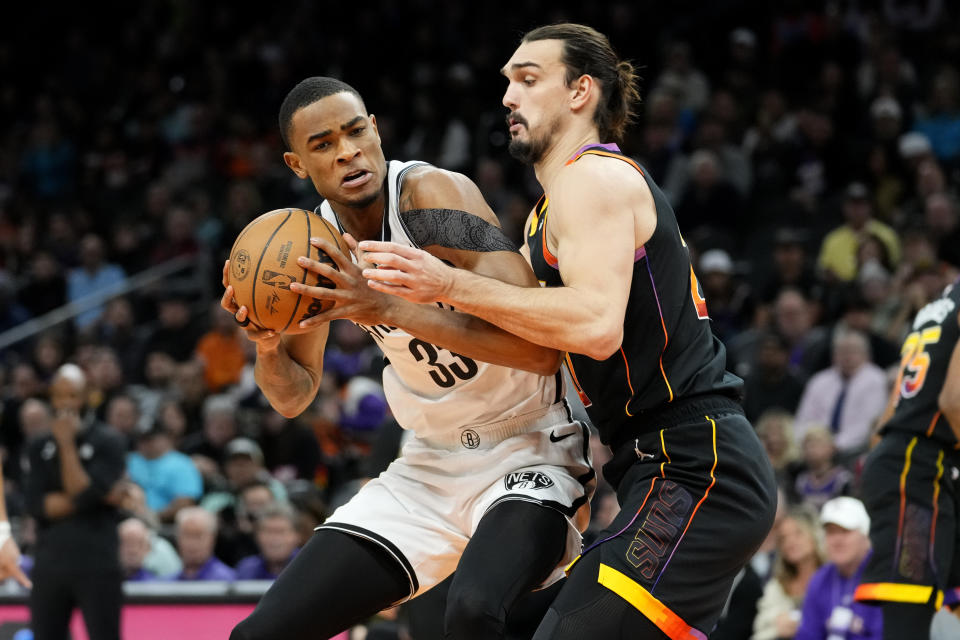 Brooklyn Nets center Nic Claxton (33) backs down Phoenix Suns forward Dario Saric during the first half of an NBA basketball game, Thursday, Jan. 19, 2023, in Phoenix. (AP Photo/Matt York)