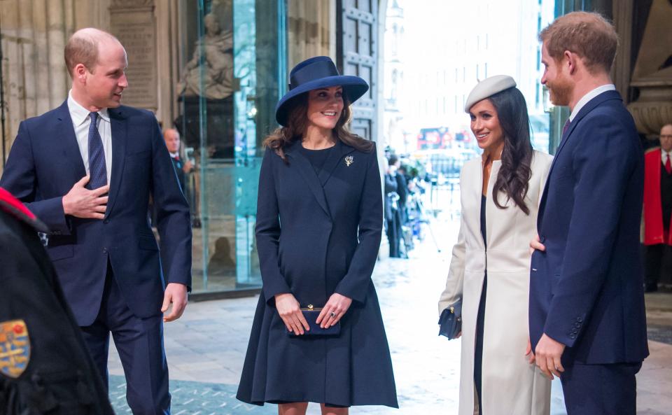 Prince William, Kate Middleton, Meghan Markle, and Prince Harry at an event. Kate Middleton is pregnant.