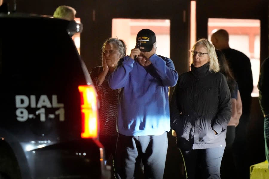 People depart a reunification center early Thursday, Oct. 26, 2023, at Auburn Middle School, in Auburn, Maine, after shootings in Lewiston. (AP Photo/Steven Senne)