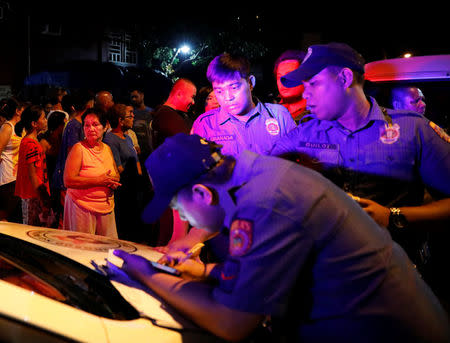Police officers write a report of a man, who police said was killed in a spate of drug-related violence overnight in Manila, Philippines August 16, 2017. REUTERS/Dondi Tawatao