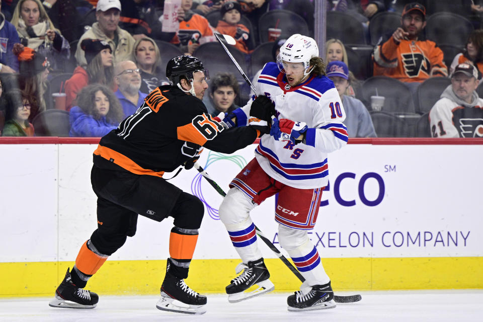 New York Rangers' Artemi Panarin, right, skates past the defense of Philadelphia Flyers' Justin Braun during the first period of an NHL hockey game, Saturday, Dec. 17, 2022, in Philadelphia. (AP Photo/Derik Hamilton)