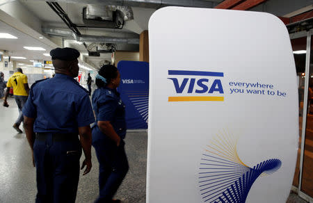 FILE PHOTO: Security staff stand next to a Visa logo at Murtala Muhammed International Airport before the arrival of the Nigerian Women’s Bobsled Team, in Lagos, Nigeria, as part of preparations ahead of the 2018 Pyeongchang Winter Olympic Games, February 1, 2018. REUTERS/Afolabi Sotunde