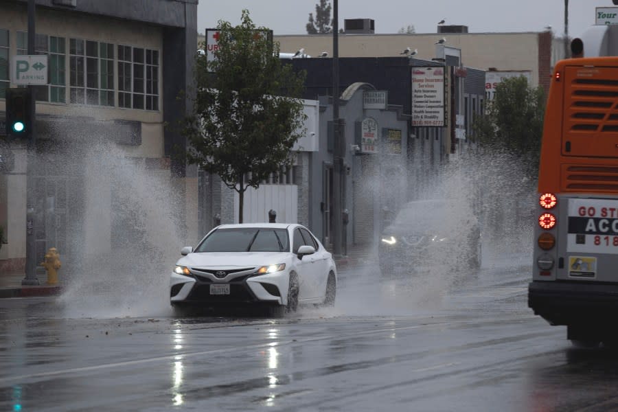 A vehicle splashes through puddles along a street starting to flood in the Van Nuys section of Los Angeles as a tropical storm moves into the area on Sunday, Aug. 20, 2023. Tropical Storm Hilary is no longer a hurricane but it's still packing what forecasters call "life-threatening" rain as it speeds up Mexico's Baja coast toward Southern California. (AP Photo/Richard Vogel)