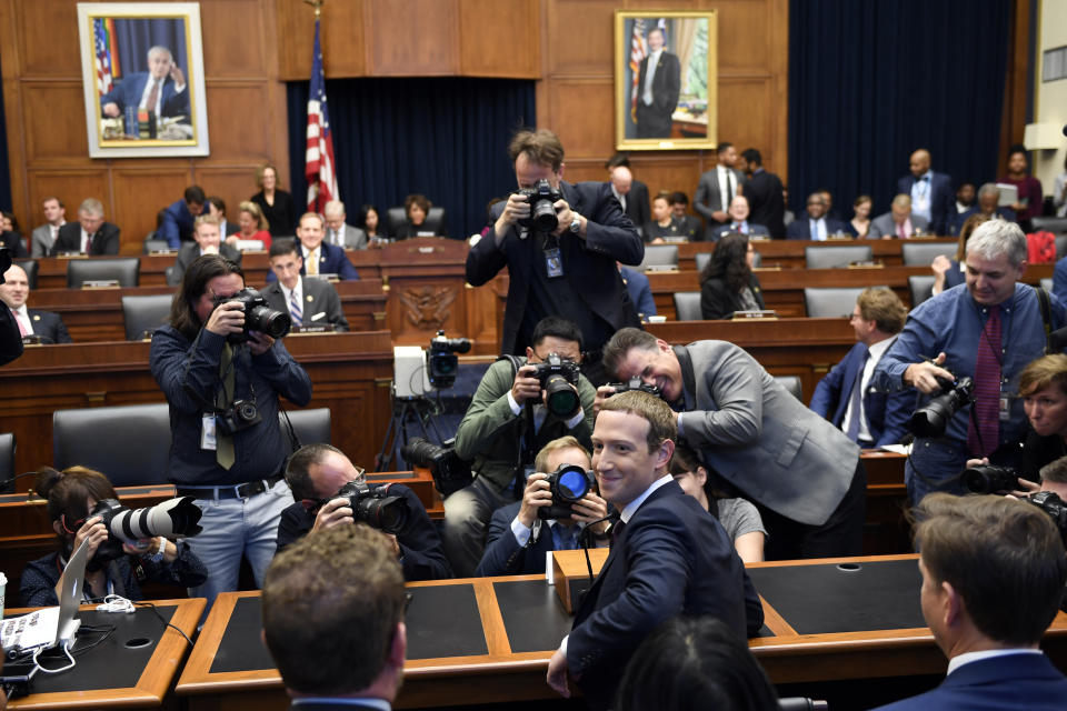 Facebook Chief Executive Officer Mark Zuckerberg, front center, turns back and smiles after arriving for a hearing before the House Financial Services Committee on Capitol Hill in Washington, Wednesday, Oct. 23, 2019. (AP Photo/Susan Walsh)