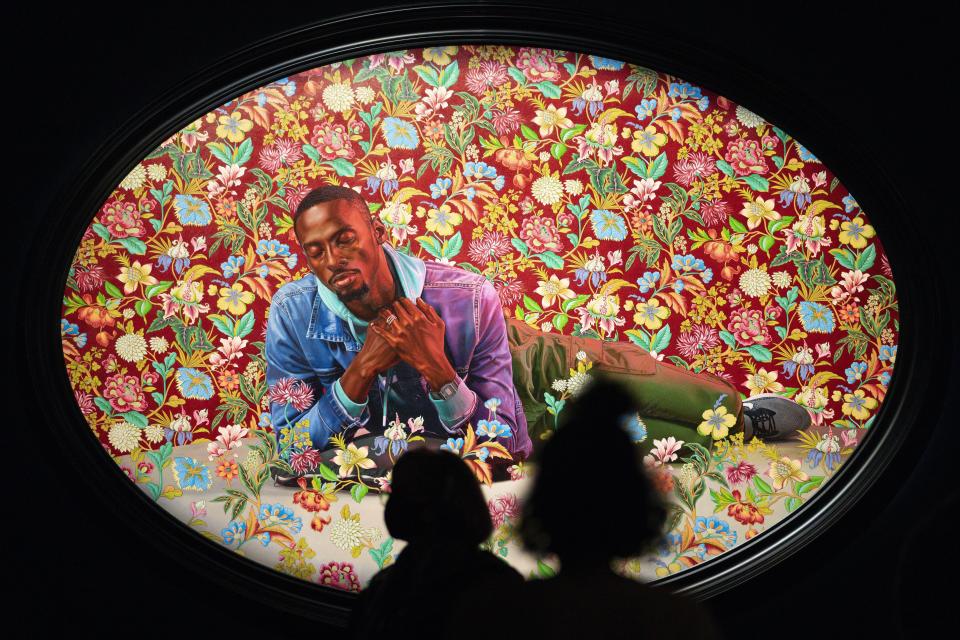 People look at a painting by Kehinde Wiley titled "Christian Martyr Tarcisius," at the de Young Museum in San Francisco, Friday, March 24, 2023. The painting is part of the "Kehinde Wiley: An Archaeology of Silence," exhibition. (AP Photo/Godofredo A. Vásquez)