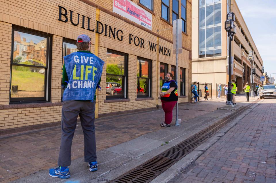 Anti-abortion protester Jeff Asmussen, left, attempts to talk to a clinic escort, Thursday, July 7, 2022, at WE Health Clinic in Duluth, Minn. Protesters like Asmussen are often seen outside the clinic during days when abortions are taking place. "I want to be a witness to the dignity of human life," Asmussen said. "We're rallying the troops out here and offering women going in there a true choice." (AP Photo/Derek Montgomery)