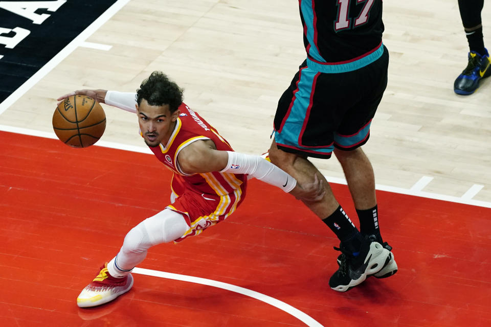 Atlanta Hawks guard Trae Young (11) goes around Memphis Grizzlies center Jonas Valanciunas (17) in the second half of an NBA basketball game Wednesday, April 7, 2021, in Atlanta. (AP Photo/John Bazemore)