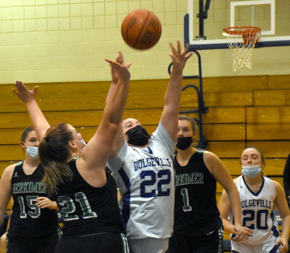 Dolgeville Blue Devil Jennifer Jablonski (22) puts up a shot between Herkimer Magicians Kaitlynn Ovitt (21) and Arrissa Bunker (1) during the first half of a Dec. 13 game played in Dolgeville.