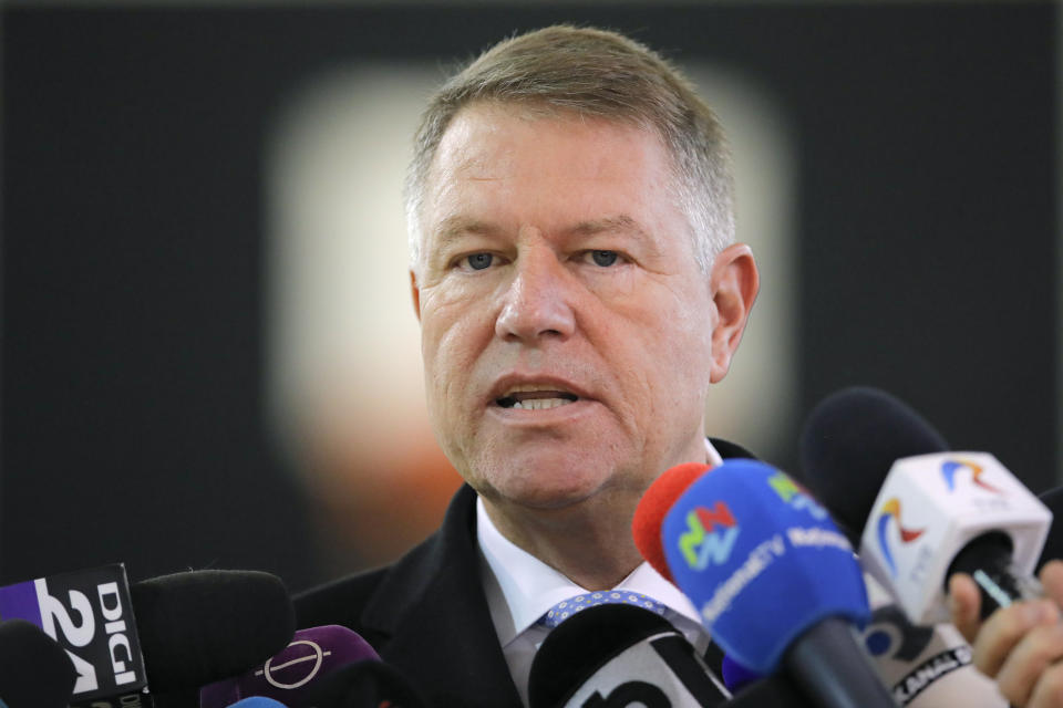 Romanian President Klaus Iohannis speaks to the media after casting his vote in Bucharest, Romania, Sunday, Nov. 24, 2019. Romanians are voting in a presidential runoff election in which incumbent Klaus Iohannis is vying for a second term, facing Social Democratic Party leader Viorica Dancila, a former prime minister, in Sunday's vote. (AP Photo/Vadim Ghirda)