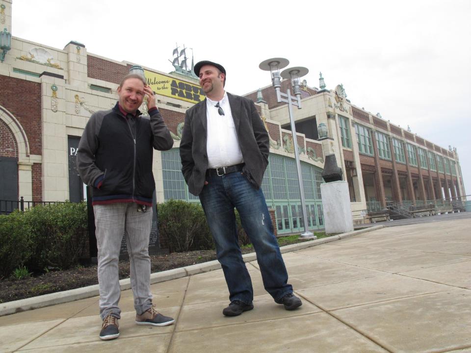 In this May 9, 2012 photo, Christian McKnight, left, senior talent buyer for concert promoter Live nation, discusses the upcoming Bamboozle Festival with Scott O'Donnell, the company's executive director of programming and festivals, in front of the Paramount Theater in Asbury Park, N.J. The theater is one of seven stages that will be used for the May 18-20 concert, headlined by Bon Jovi. (AP Photo/Wayne Parry)