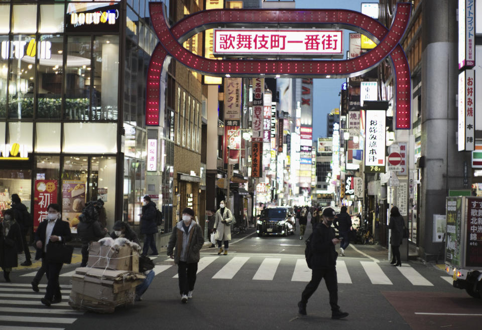 Varias personas, con mascarilla para ayudar a frenar la propagación del coronavirus, cruzan una calle en el vecindario de Shinjuku, en Tokio, el 7 de enero de 2021. (AP Foto/Hiro Komae)