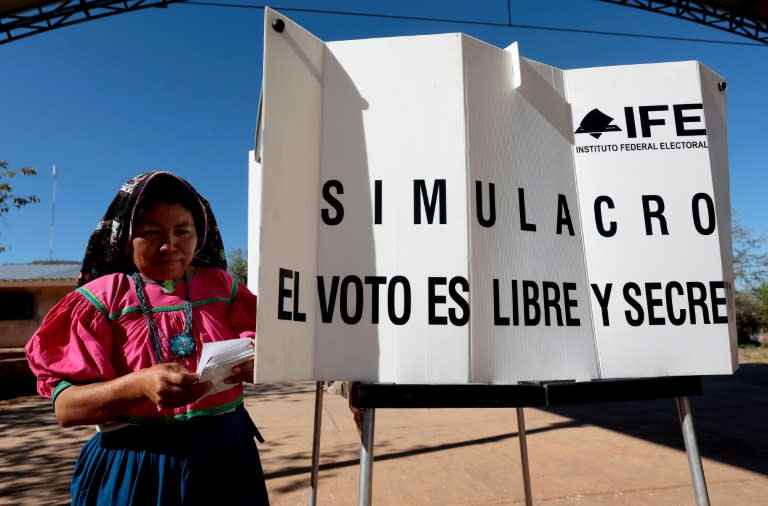 A member of Mexico's Wixarika Indigenous community casts a ballot during a rehearsal for upcoming local and national elections (ULISES RUIZ)