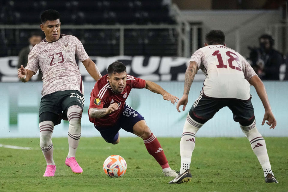 Costa Rica defender Jefry Valverde (22) is tripped by Mexico defender Jesús Gallardo (23) during the first half of a CONCACAF Gold Cup soccer quarterfinal Saturday, July 8, 2023, in Arlington, Texas. (AP Photo/Sam Hodde)