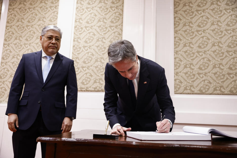 U.S. Secretary of State Antony Blinken, right, writes in a guest book as he meets with Philippines' Secretary of Foreign Affairs Enrique Manalo at the Sofitel Hotel in Manila, Philippines Tuesday, March 19, 2024. (Evelyn Hockstein/Pool Photo via AP)