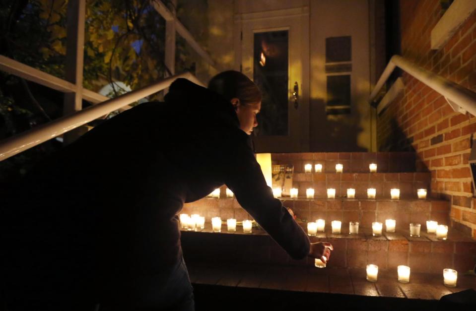 A woman places a candle on the steps of Chicago Chef Charlie Trotter's former restaurant after friends and former employees of Trotter's placed them there after a candle light tribute to Trotter, Tuesday, Nov. 5, 2013, in Chicago. Trotter, 54, died Tuesday, a year after closing his namesake Chicago restaurant that was credited with putting his city at the vanguard of the food world and training dozens of the nation's top chefs, including Grant Achatz and Graham Elliot. (AP Photo/Charles Rex Arbogast)
