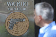 People walk past the Waikiki Gun Club, Thursday, June, 23, 2022 in Honolulu. In a major expansion of gun rights after a series of mass shootings, the Supreme Court said Thursday that Americans have a right to carry firearms in public for self-defense.