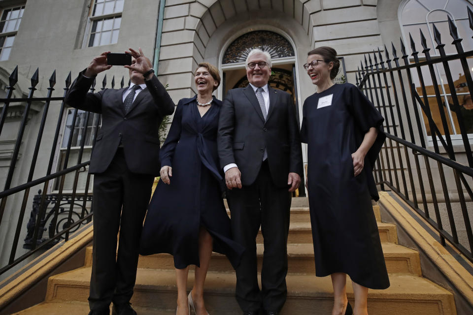 German President Frank-Walter Steinmeier, second from right, poses for a photo with his wife, Elke Budenbender, left, and Director of Goethe Institute Boston, Marina May, far right, as Goethe Institute Secretary General Johannes Ebert, far left, takes a picture with his phone on the steps of the Goethe Institute, Thursday, Oct. 31, 2019, in Boston. (AP Photo/Elise Amendola)