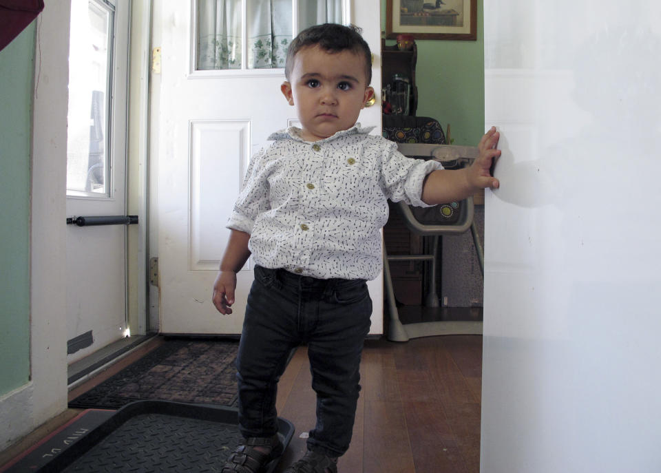 In this Aug. 5, 2019 photo, Danyal Alhallak stands in the kitchen of his family's apartment in Rutland, Vt. His parents, sister and brother fled the war in Syria in 2015 and now the family is rebuilding a life for themselves in Vermont. (AP Photo/Lisa Rathke)