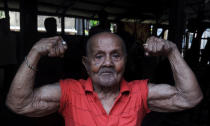Indian body builder Manohar Aich shows his muscles on the eve of his 100th birthday, in a gymnasium in Kolkata on March 16, 2012.