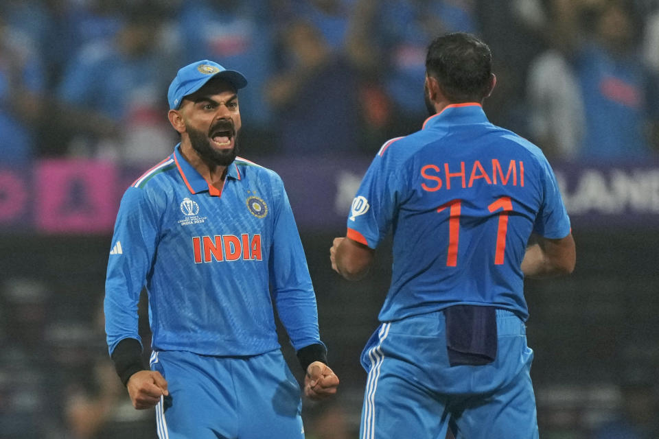 India's Mohammed Shami, right, celebrates with teammate Virat Kohli the wicket of New Zealand's Rachin Ravindra during the ICC Men's Cricket World Cup first semifinal match between India and New Zealand in Mumbai, India, Wednesday, Nov. 15, 2023. (AP Photo/Rajanish Kakade)