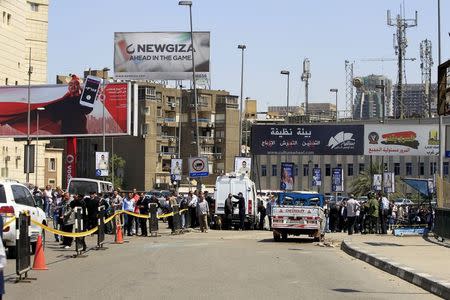 Security officials inspect the scene of a car bomb blast on a bridge in the Cairo district of Zamalek, April 5, 2015. REUTERS/Mohamed Abd El Ghany