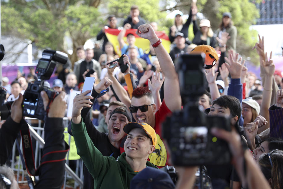 McLaren driver Oscar Piastri of Australia, center bottom, poses for photos with fans as he arrives at the track ahead of the Australian Formula One Grand Prix at Albert Park in Melbourne, Thursday, March 30, 2023. (AP Photo/Asanka Brendon Ratnayake)