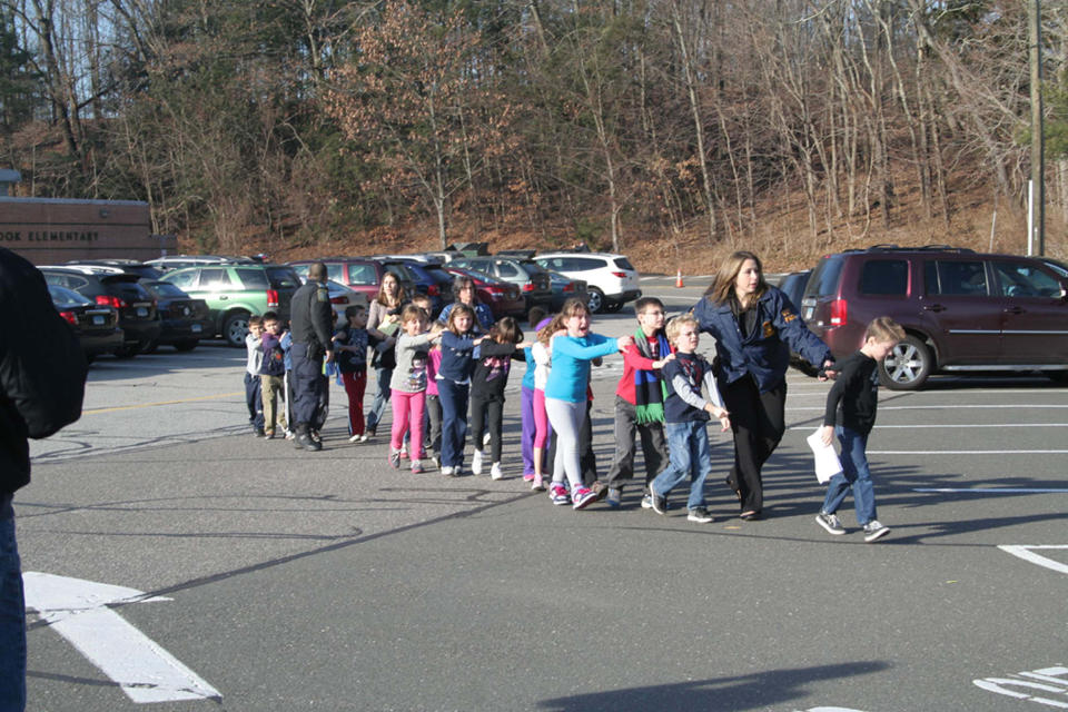 Connecticut State Police lead students from the Sandy Hook Elementary School to safety after a mass shooting on Dec. 14, 2012. | Shannon Hicks—Newtown Bee/Polaris