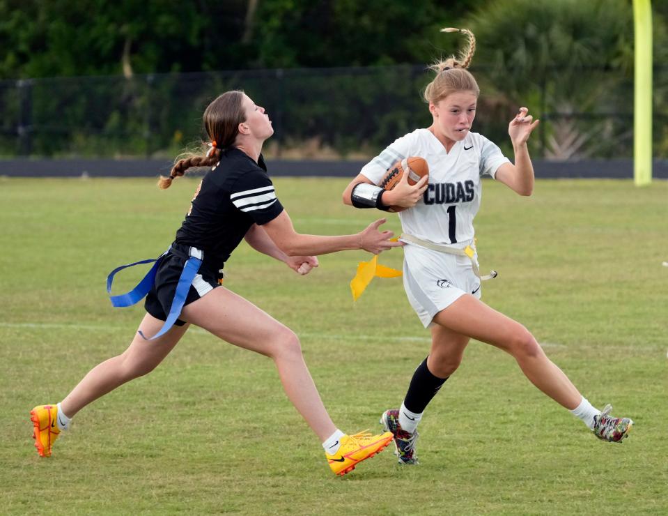 New Smyrna QB Emma Corr (1) attempts to elude tackle during a flag football game with Spruce Creek at Spruce Creek High school in Port Orange, Thursday, April 18, 2024.