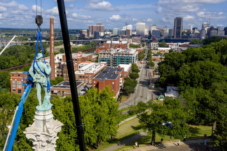 Crews work to remove the Confederate Soldiers & Sailors Monument in Libby Hill Park, Wednesday, July 8, 2020, in Richmond, Va. The 17 ft statue stands on a 73 foot pedestal overlooking downtown. The statue is one of several that will be removed by the city as part of the Black Lives Matter reaction. (AP Photo/Steve Helber)
