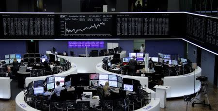 Traders work at their desks in front of the German share price index, DAX board, at the stock exchange in Frankfurt, Germany, April 27, 2017. REUTERS/Staff/Remote