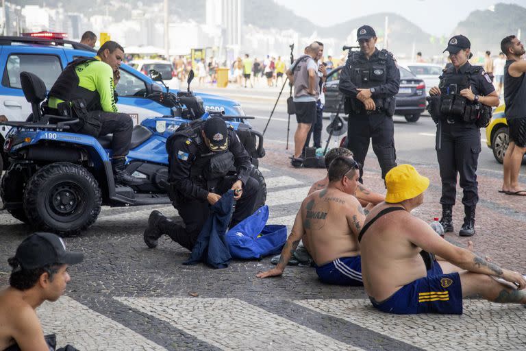 Policías inspeccionan las mochilas de fanáticos de Boca Juniors en la playa de Copacabana, en las vísperas de la final de la Copa Libertadores disputada en el Maracaná.