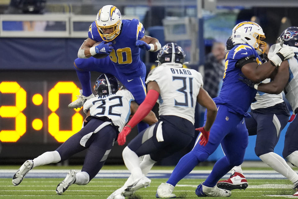 Los Angeles Chargers running back Austin Ekeler, top, runs against Tennessee Titans cornerback Greg Mabin (32) and safety Kevin Byard (31) during the second half of an NFL football game in Inglewood, Calif., Sunday, Dec. 18, 2022. (AP Photo/Marcio Jose Sanchez)